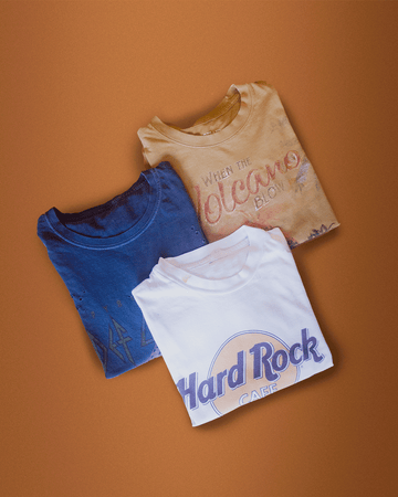 nativegood thrifted t shirt bundle (3 shirts) on an orange background
